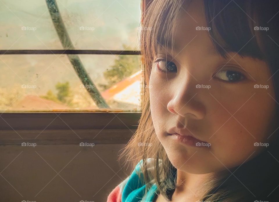 Portrait of a little girl by the window