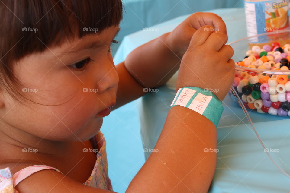 Cute girl making jewelry