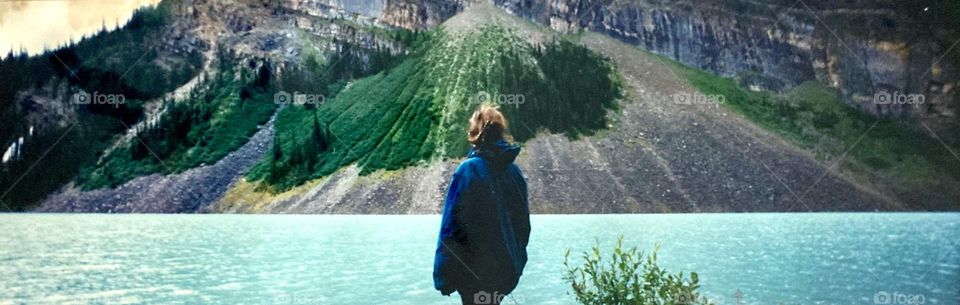 A woman enjoying the view of Fairview Mountain across Lake Louise, Alberta, Canada.