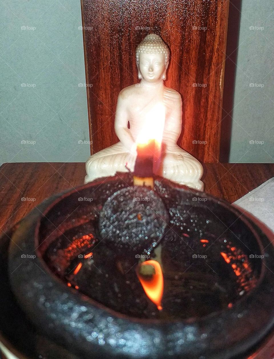 Lord Buddha and lighted oil lamp