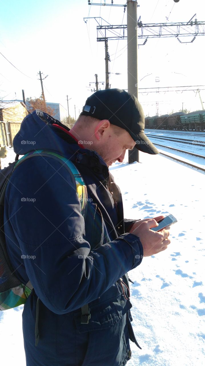 the man in the street in the winter calls for smartphone