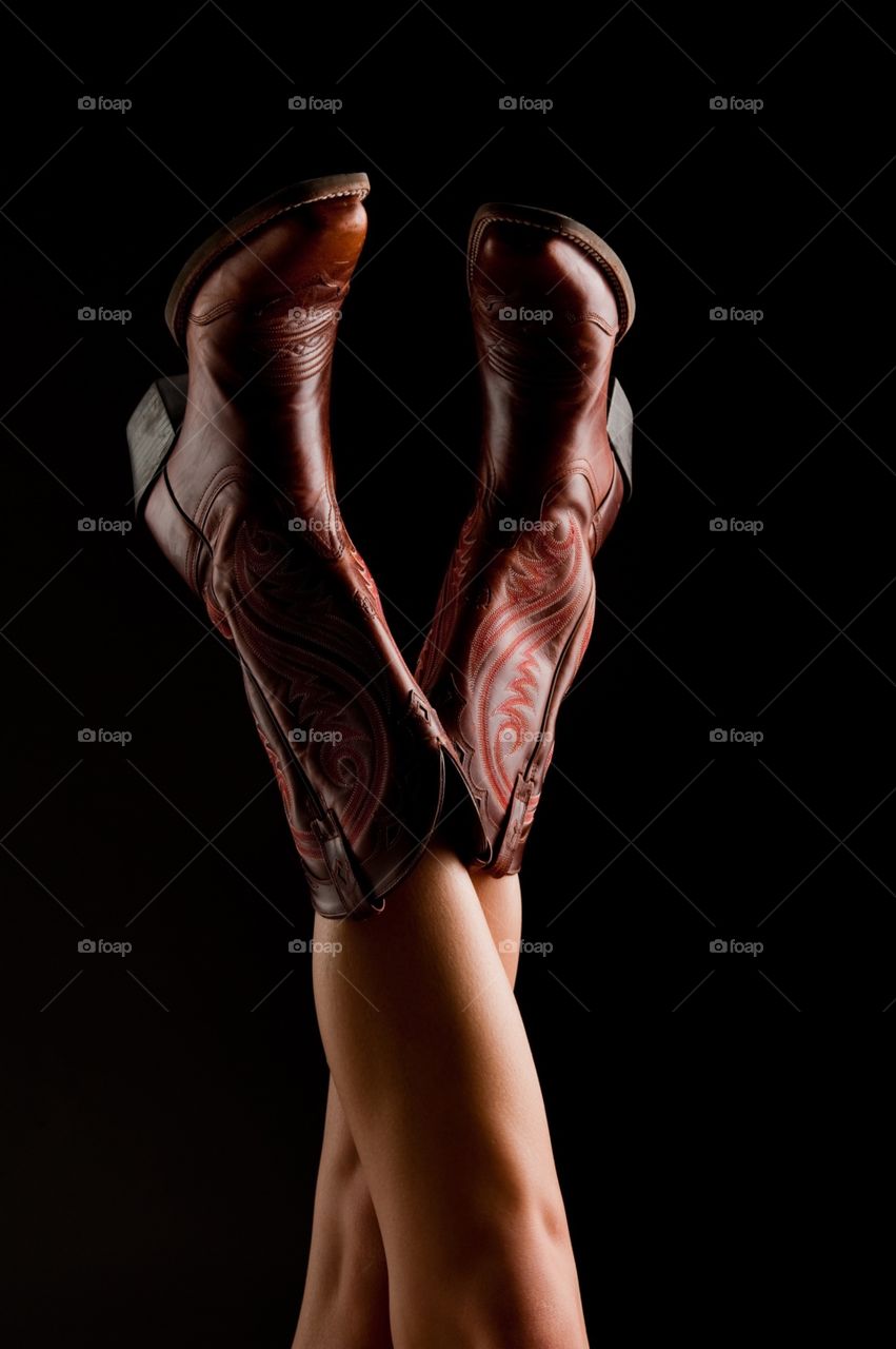 Female legs with brown cowboy boots 