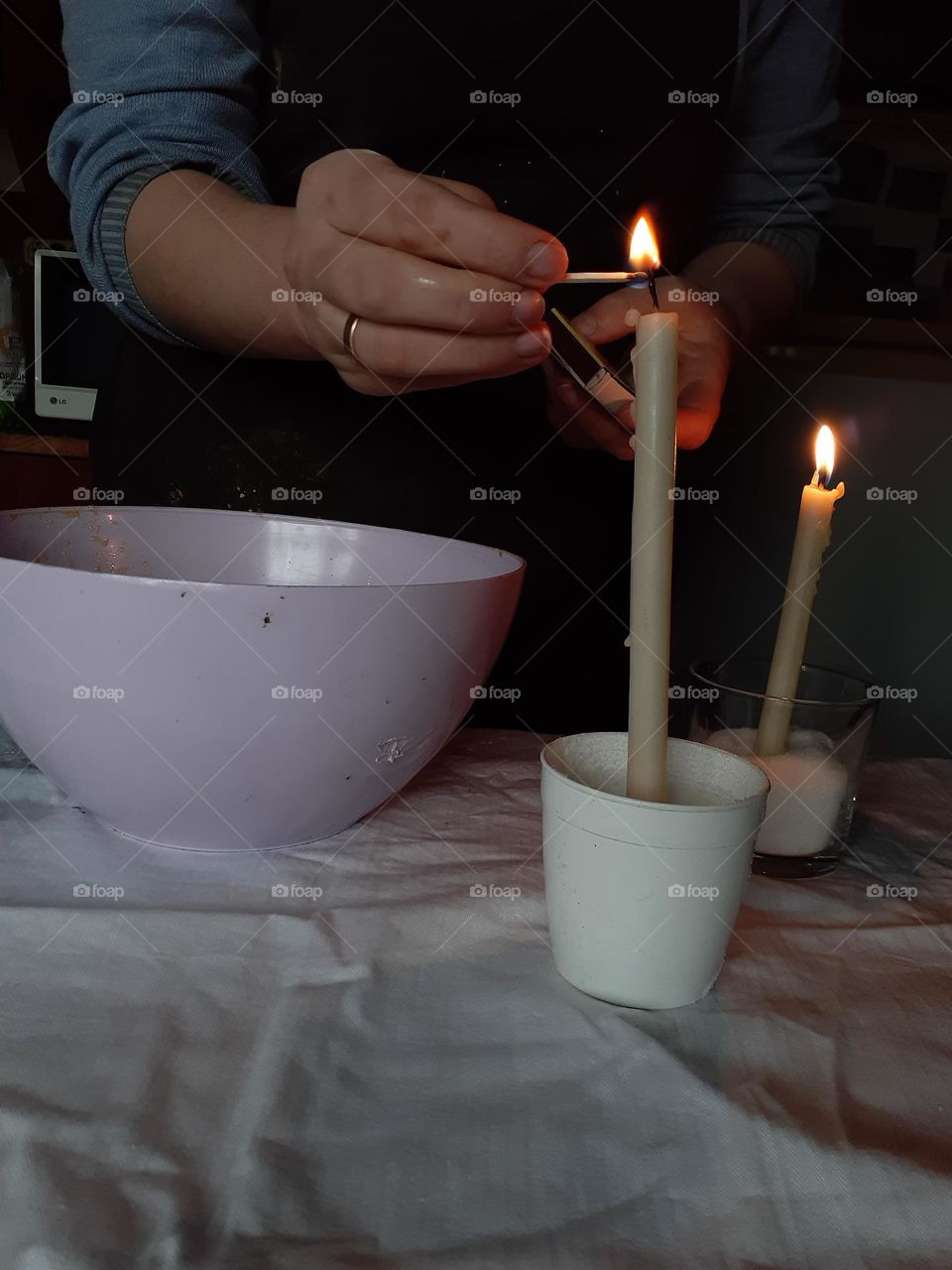 Lighting a church candle while cooking bread