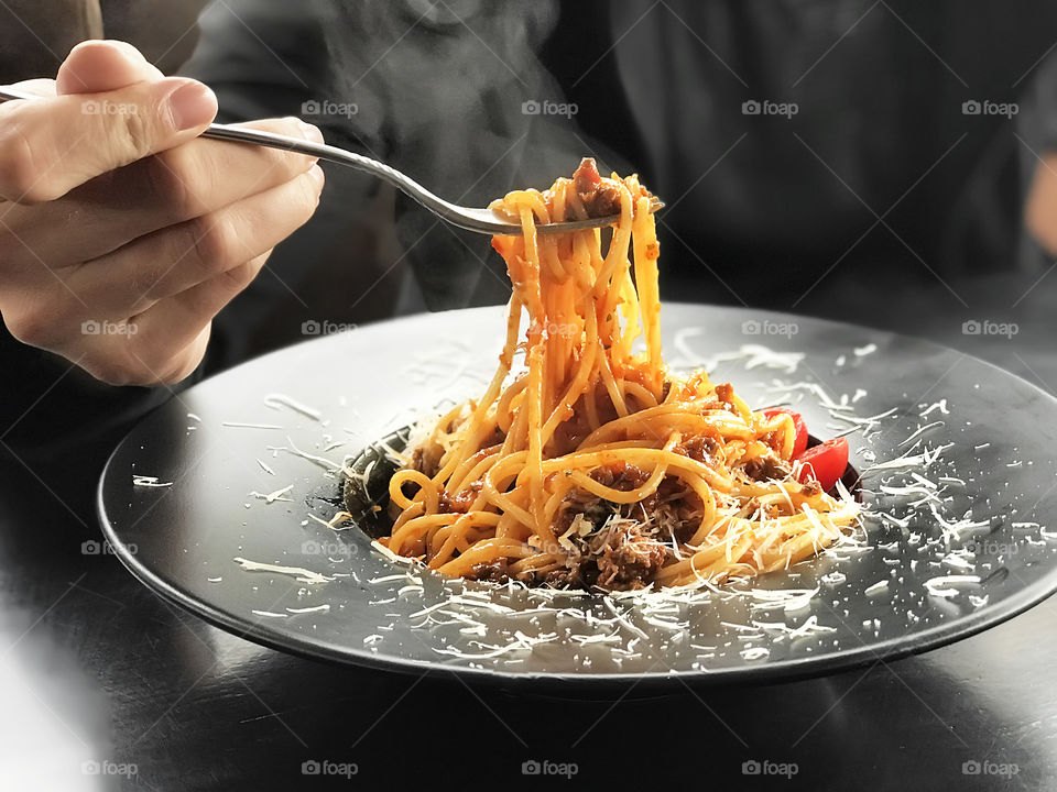 Young man enjoying his favorite hot italian pasta with seafood and tomatoes 