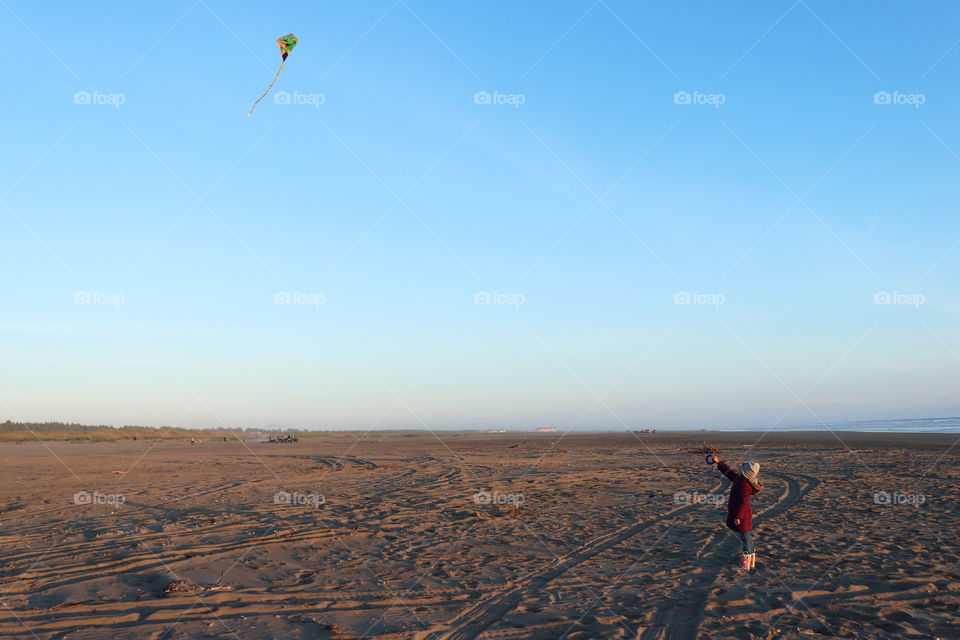 Little girl flying a kite