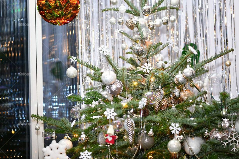 Christmas tree decorated with white toys.  many gifts under the tree