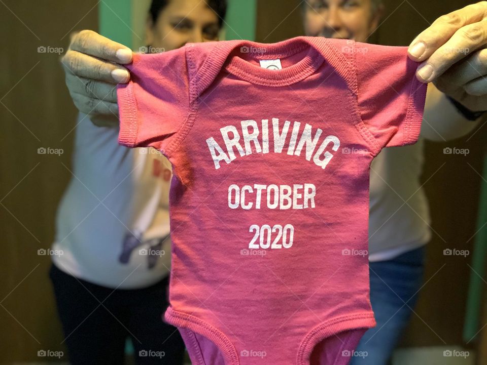 Excited about baby arrival, announcing baby’s birth, announcement on social media of baby’s birth, pink baby onesie 