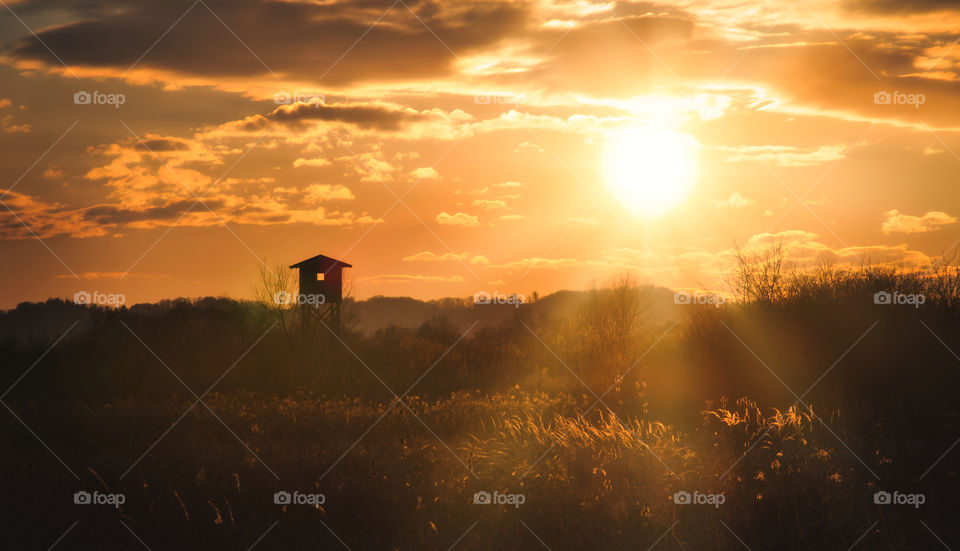 Wooden hunting house at sunset