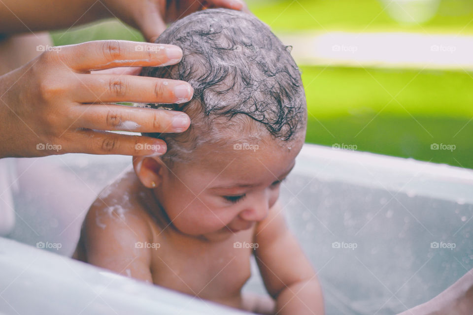 Baby's first bath in the garden on a hot summer day in Brazil