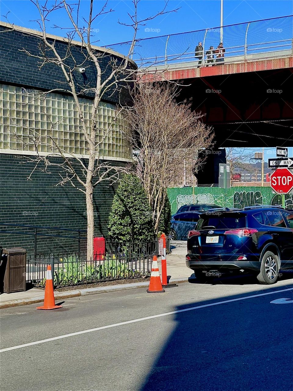 This is the ultramodern curved facade leading towards the back of “THE BOX HOUSE HOTEL” by the “Pulaski Bridge” at “Newtown Creek” in “Greenpoint”, Brooklyn recognizable by the red metal support structure across the street. 2024. Hypnotic Productions