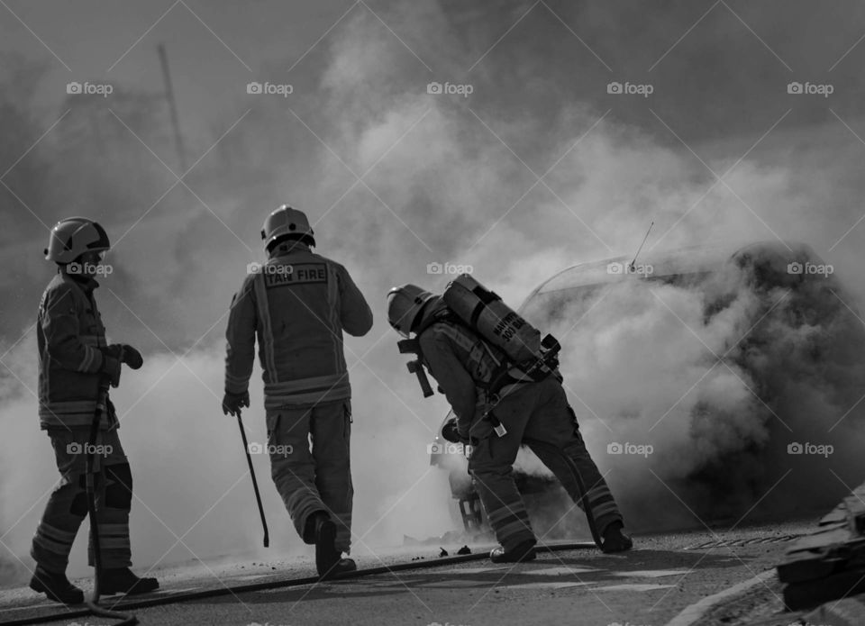Firefighter tackling a car fire. 