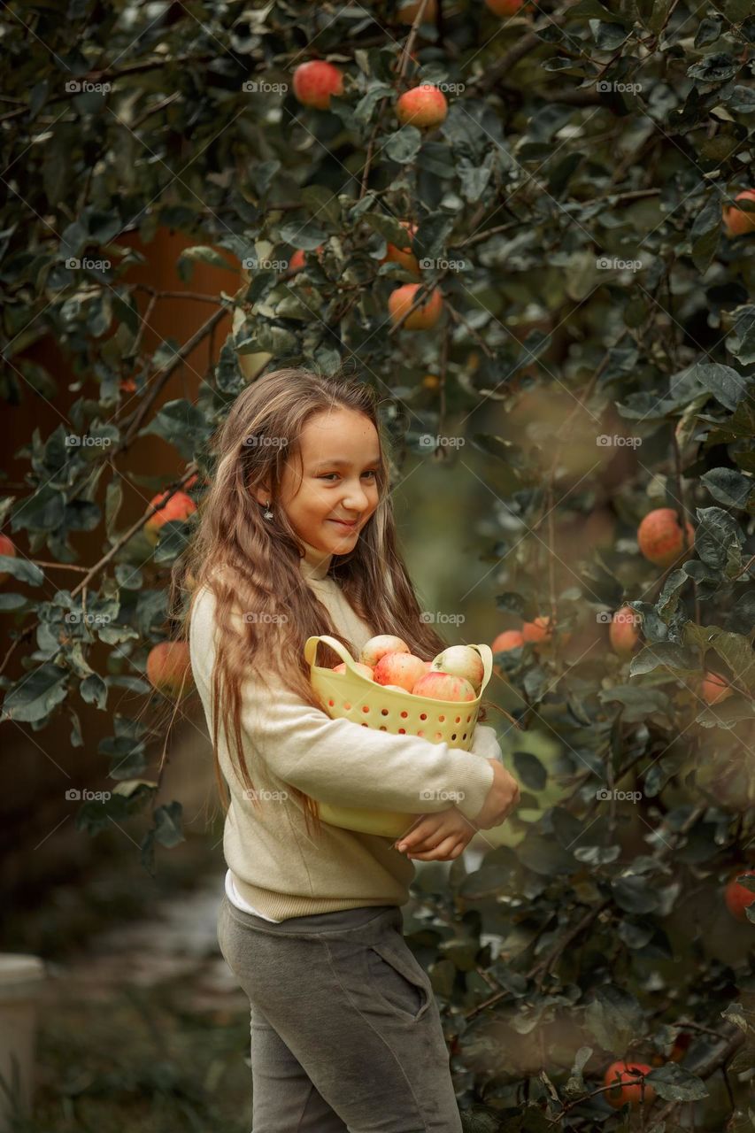 Long-haired girl with basket of apples