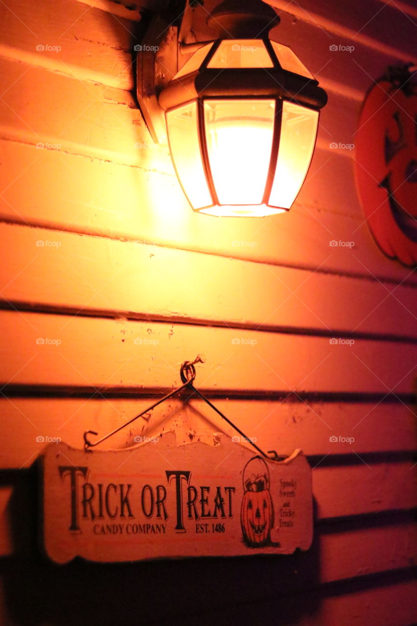 trick-or-treat sign under orange light