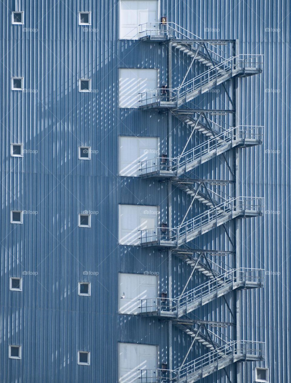 Part of a building with outside stairs and windows 