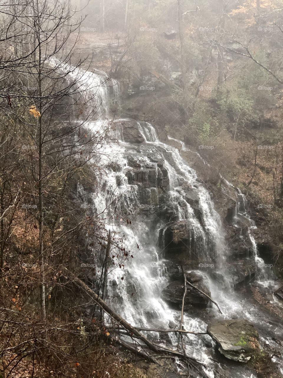 Foggy misty large waterfall in the forest