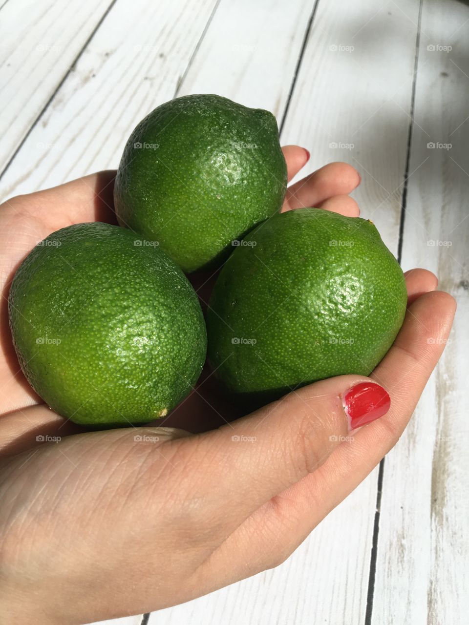 Hands holding limes 