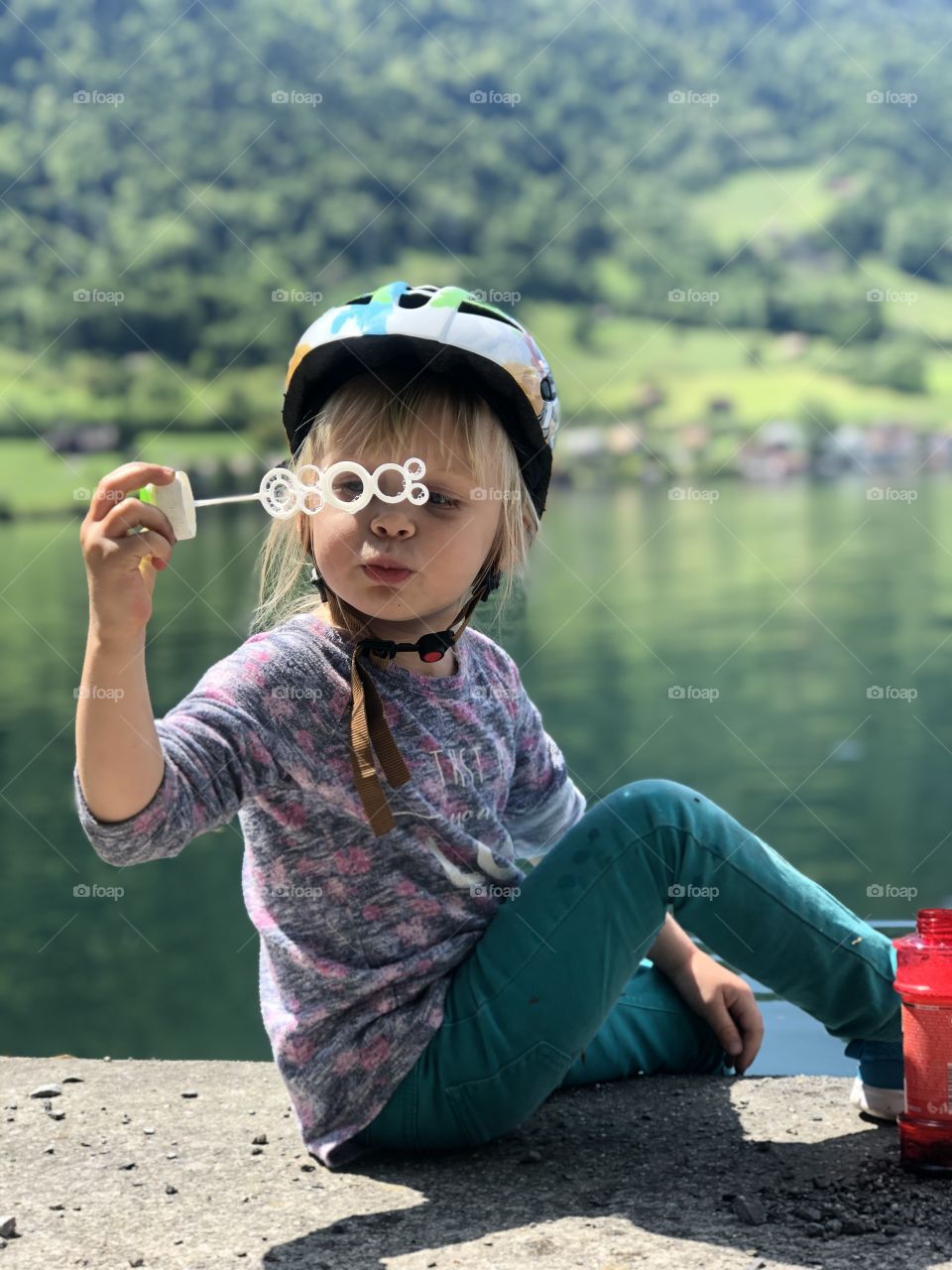 girl blowing bubbles on a lake in Switzerland