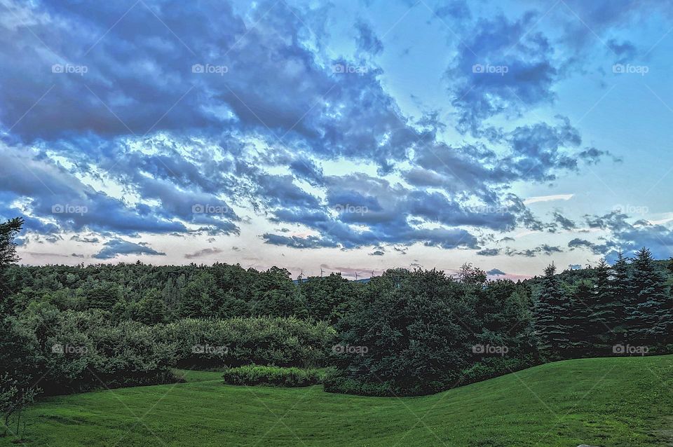 The sky in Vermont, beautiful sunset in Vermont, clouds and treeline in Vermont, out in the country in Vermont, on vacation in the woods 