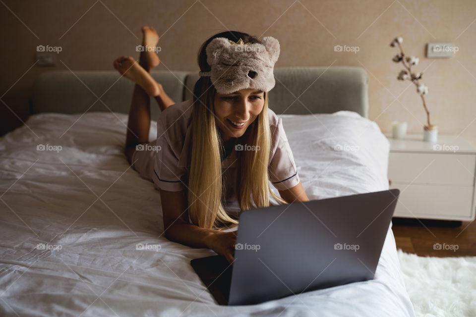 Woman using laptop on the bed