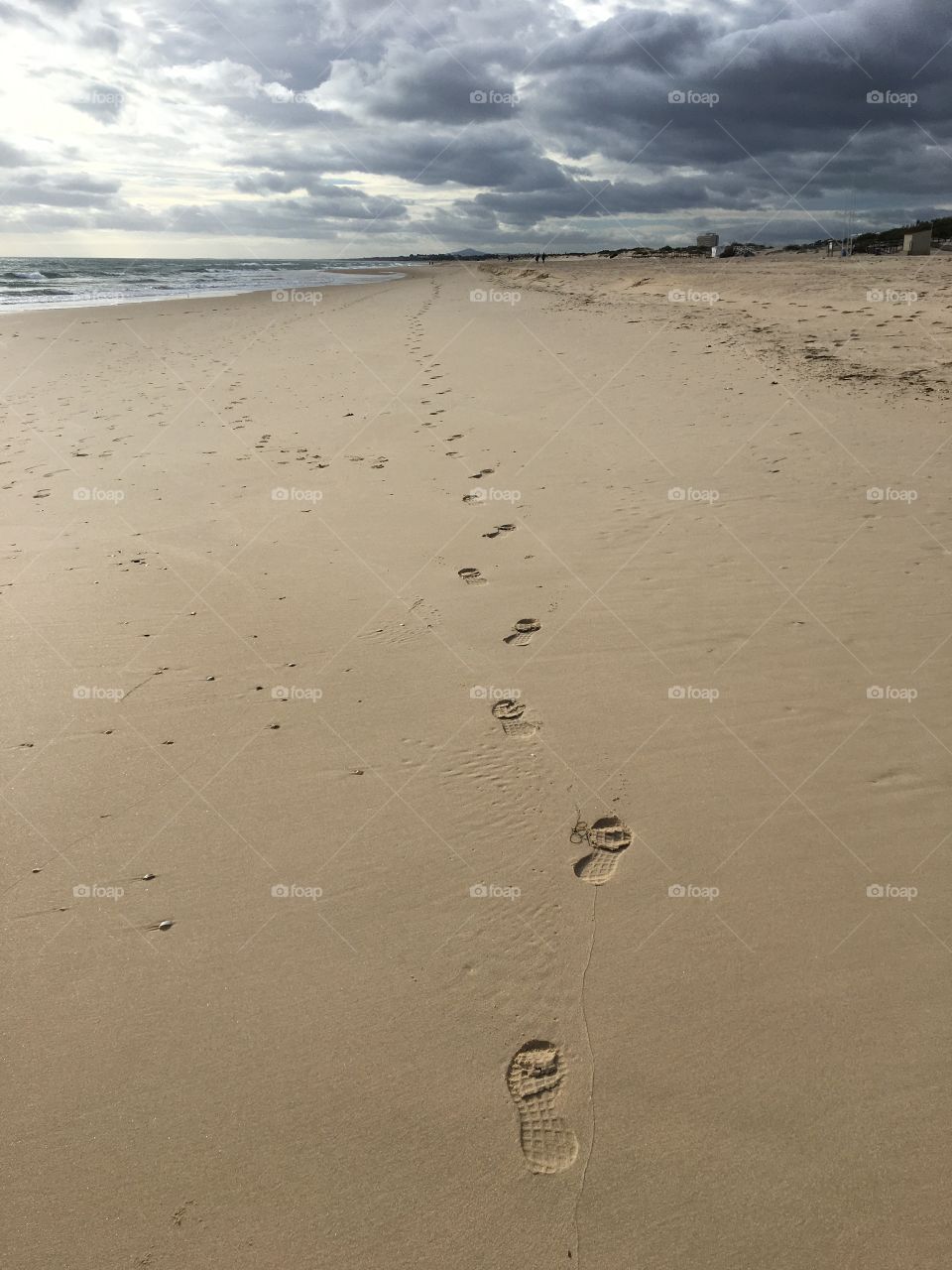Lonely footprints on wide and desert beach