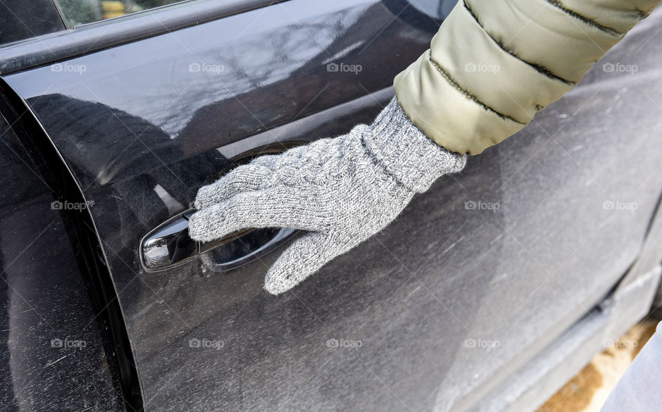 Women's gloved hand opening a car door