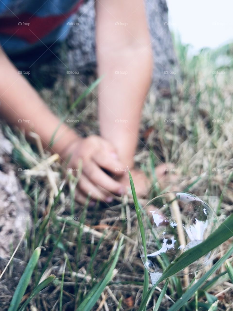 Young boy about to pop a bubble