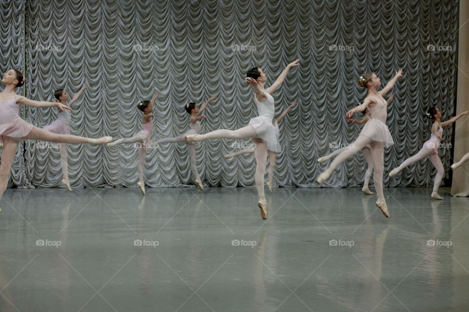 Performing young ballerinas in a jump.