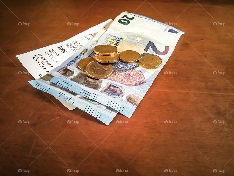 Euro note and coins on wooden table