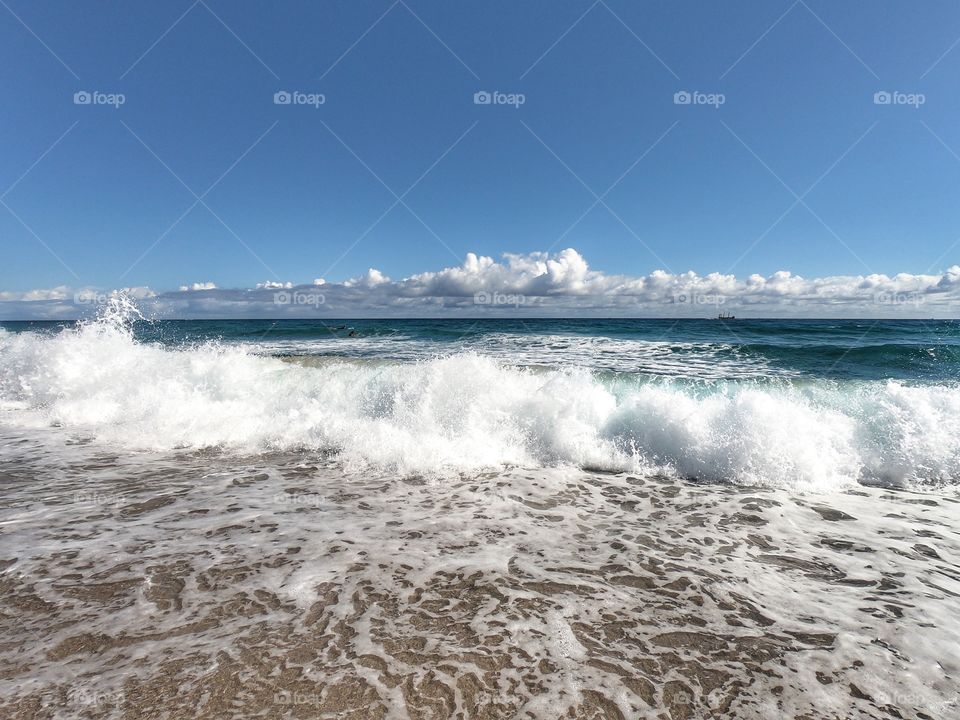 Beautiful beach in Florida, people doing swimming, surfing and boat sailing. Vacation.