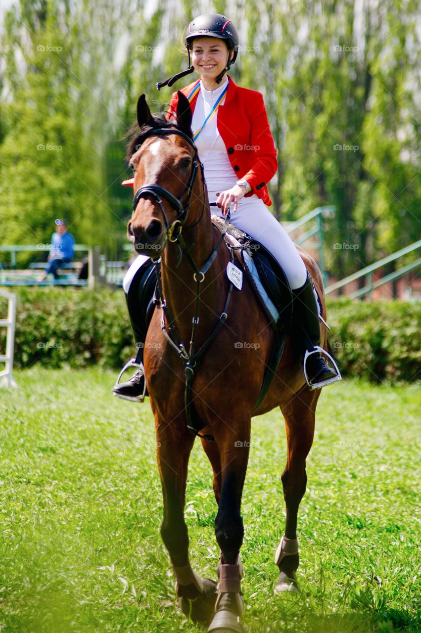 Happy young woman riding horse