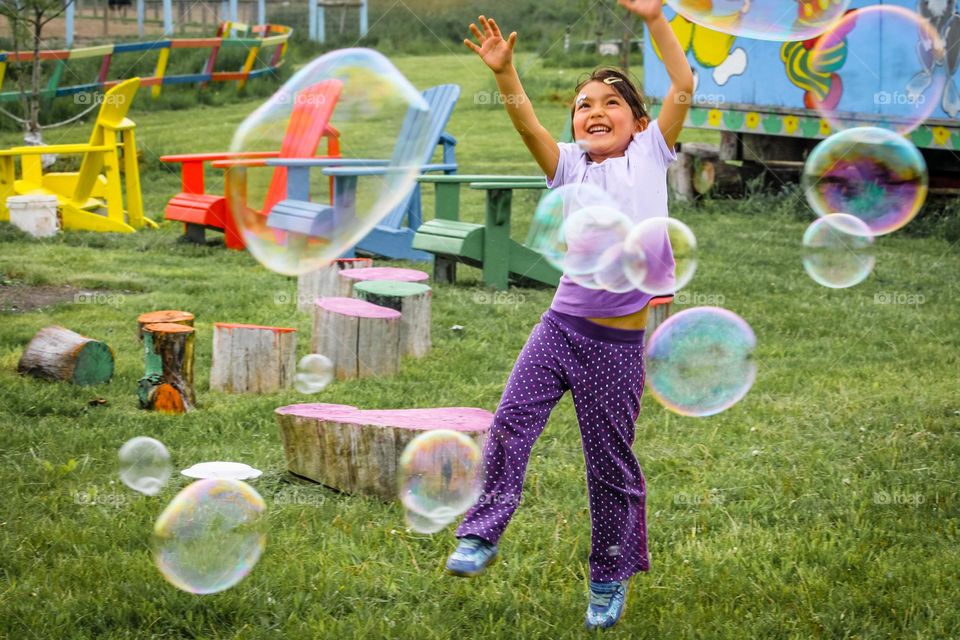 Happy time: cute little girl is playing with soapy bubbles