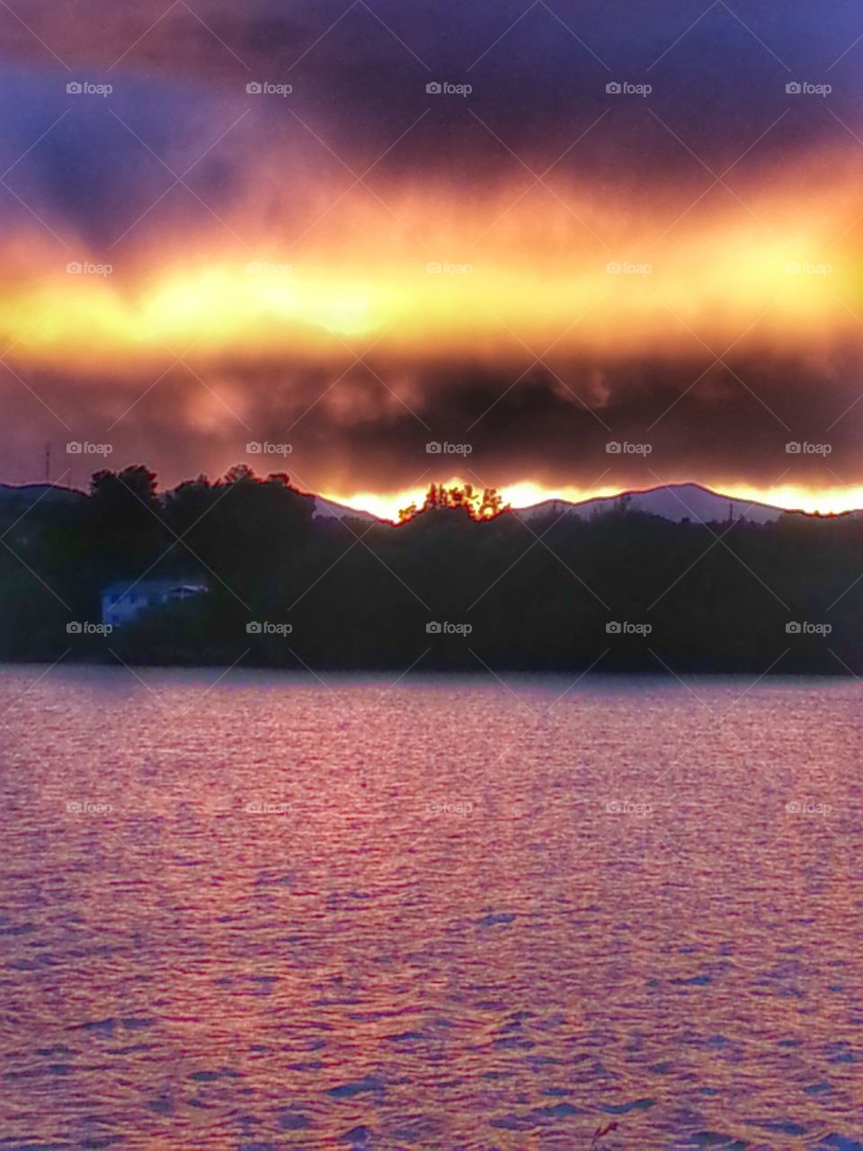 Sun Setting behind Mountain. sunset at lake in Colorado