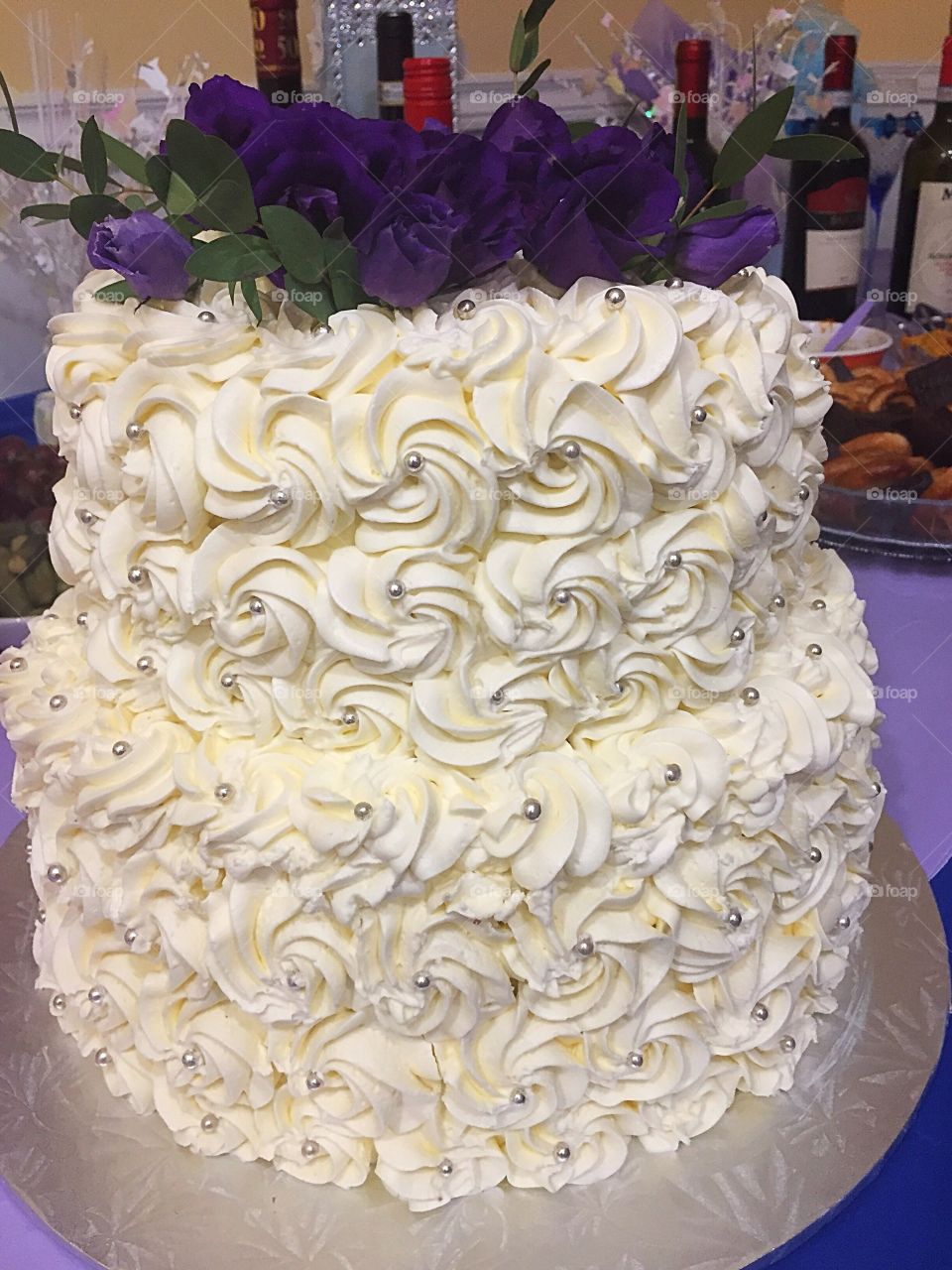 Butter cream vanilla Anniversary cake decorated fresh purple flowers on top