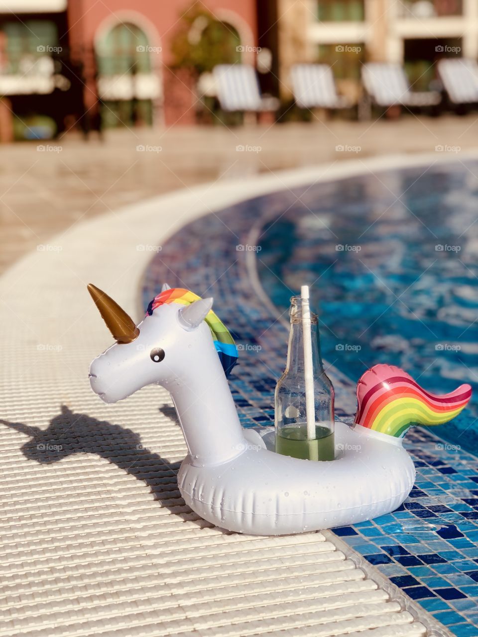 a stand in the form of a unicorn for a drink in the pool, stands on the corner of the pool.  Summer mood