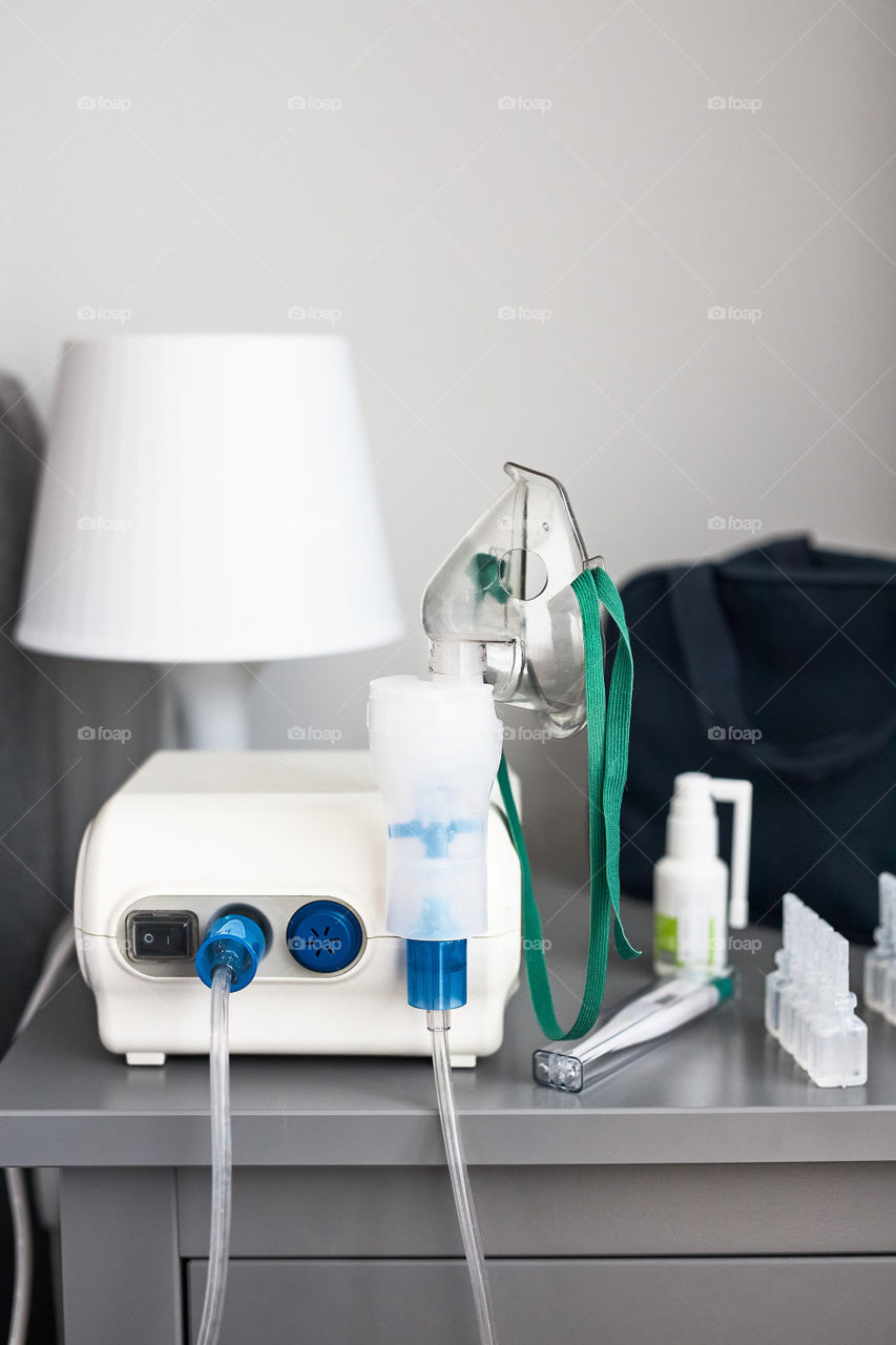 Nebuliser with breathing mask and medicines on bedside table