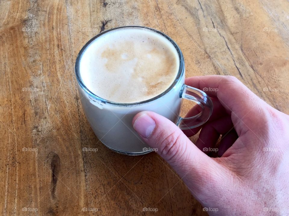 Human hand holding cup of coffee