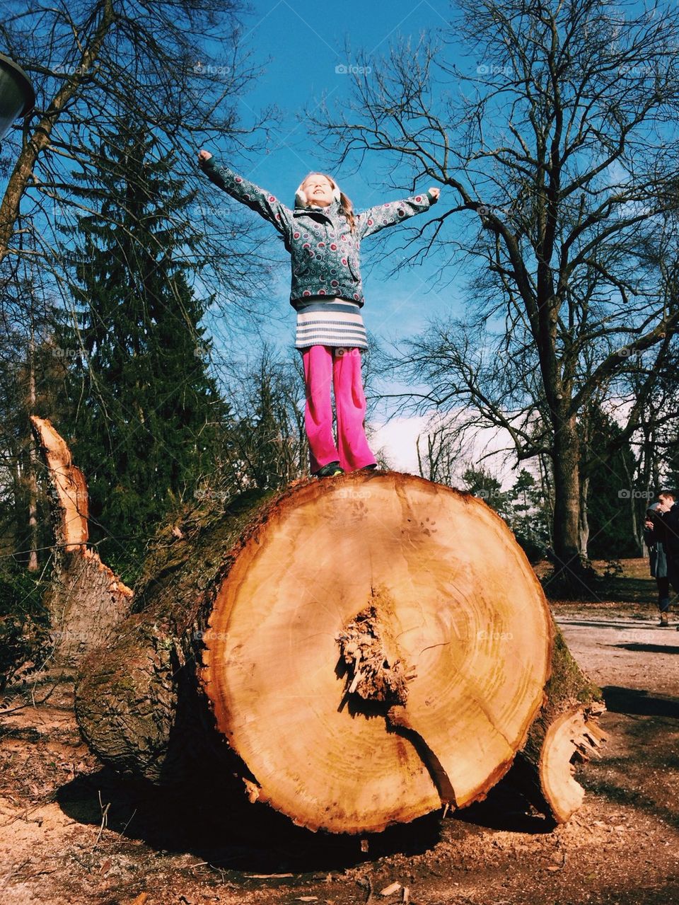 Little girl on tree trunk