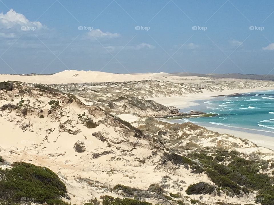 White pristine sand dunes rose up to greet the turquoise blue ocean in a remove coastal area of south Australia near Coffin Bay 