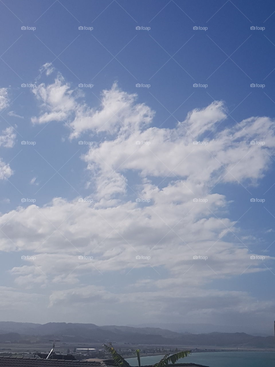 Clouds over my city on a lovely hot summers day. Imagination can find a face or other shapes if you stare for a while.