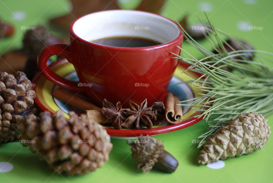 Red cup of coffee and autumn decoration