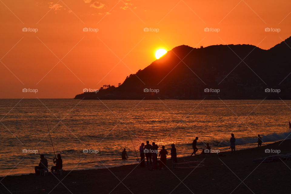 fishing on the beach in sunset