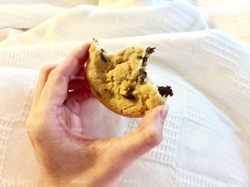 A half eaten chocolate chip cookie 