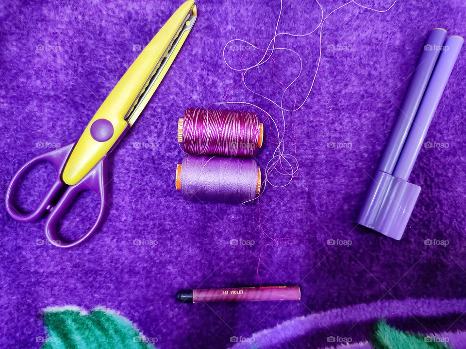 Purple Thread, Scissors, Sketch and crayons in the purple background