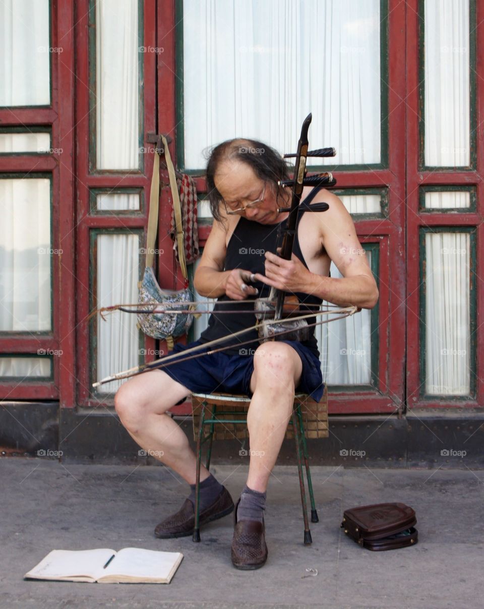 Musician plays the erhu. Chinese musician