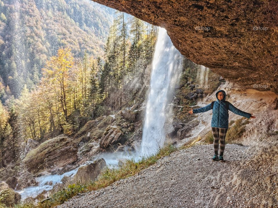 Woman traveler at the waterfall in slovenian mountains.