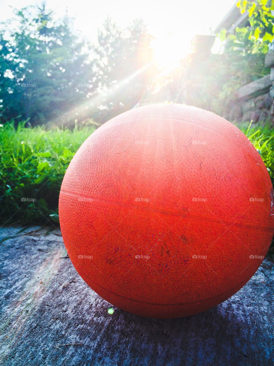 Basketball at sundown. The glow of the evening sun on the basketball in the yard.