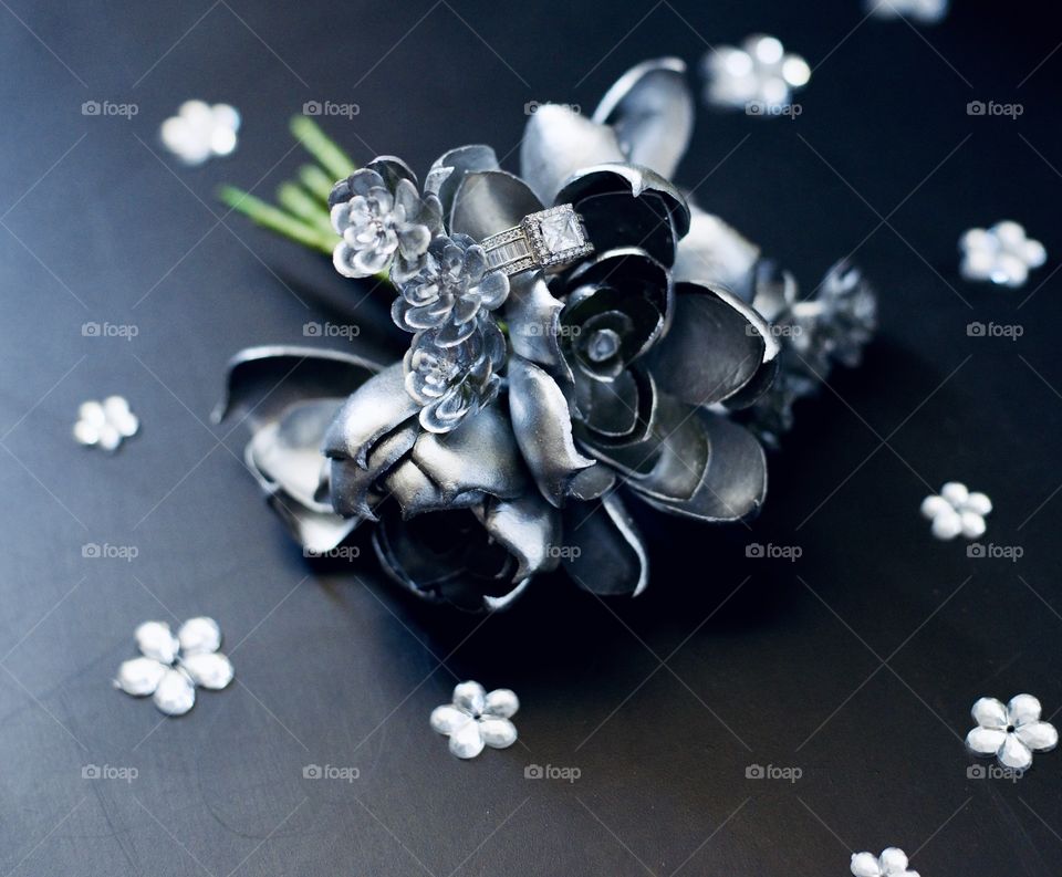 Diamond ring on an artificial silver rose with a green stem