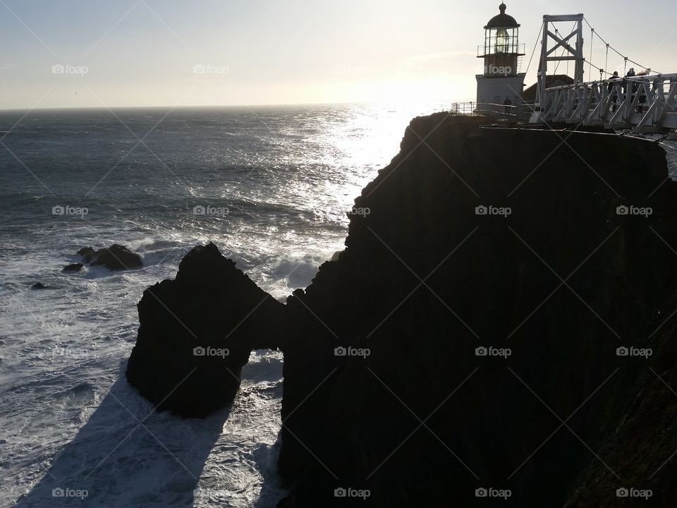 Light house and bridge on jagged sea coast