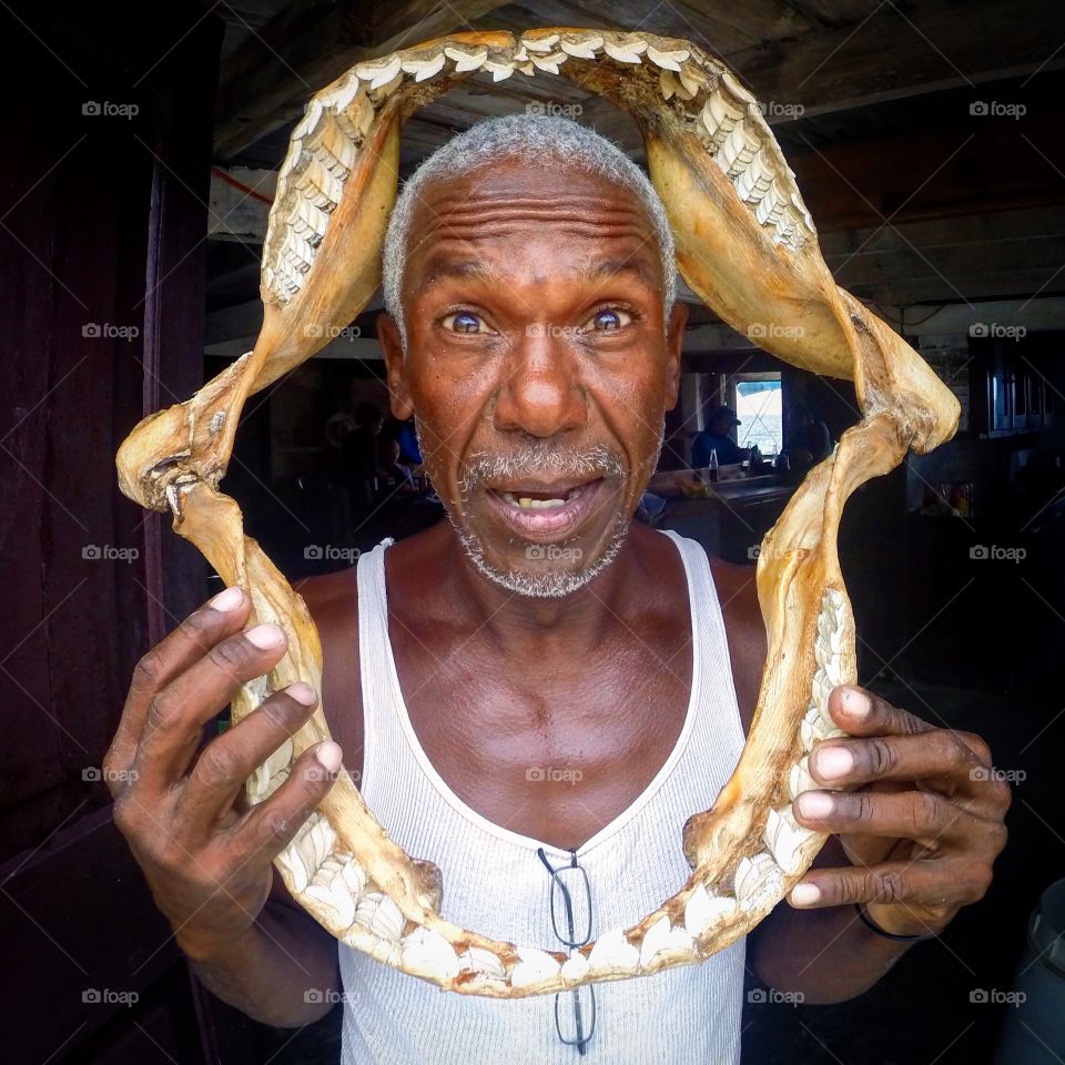 Portrait of senior man holding jaws of shark skeleton