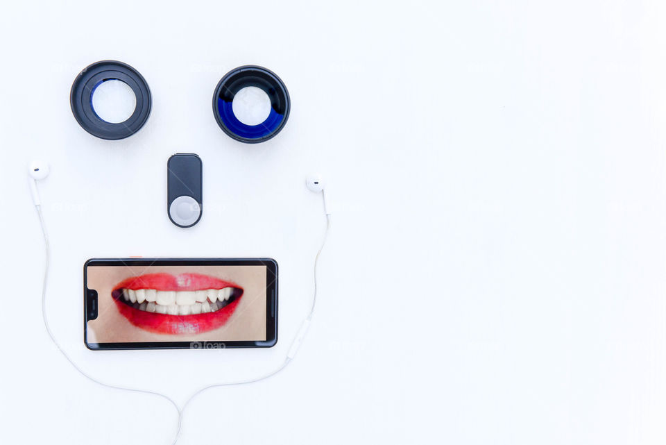 Flat lay of technology gadgets arranged to make a face